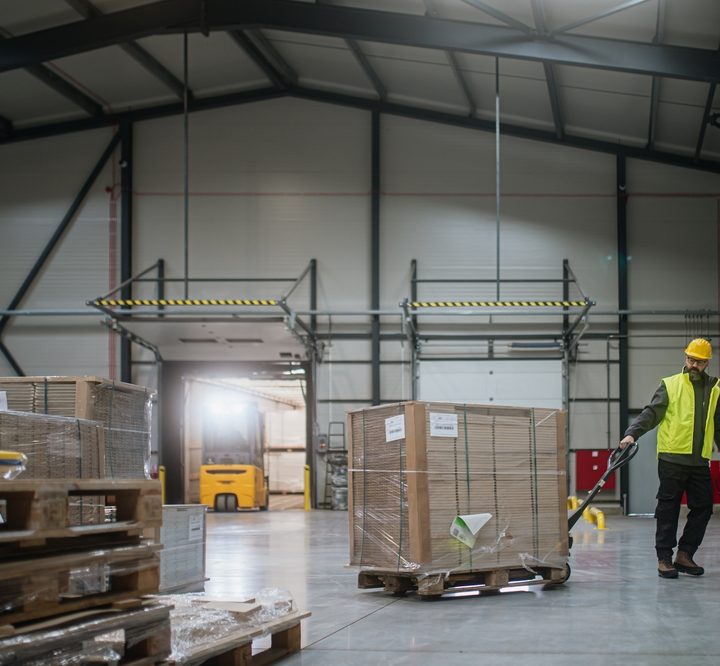Warehouse employee moving pallets during ERP receiving operations at a loading dock