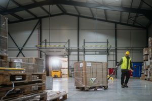 Warehouse employee moving pallets during ERP receiving operations at a loading dock