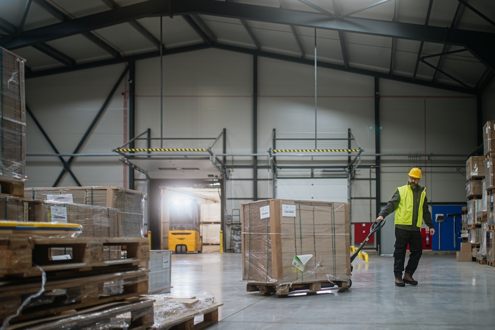 Warehouse employee moving pallets during ERP receiving operations at a loading dock