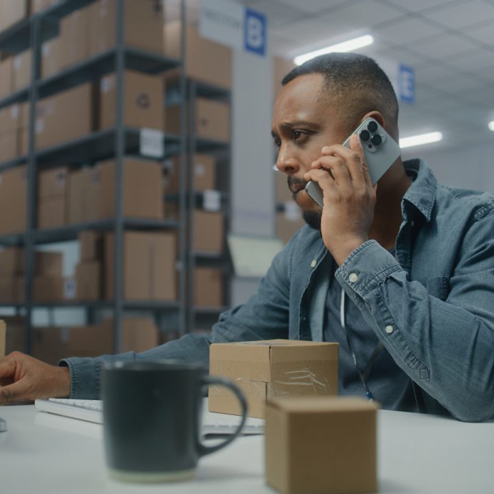 Warehouse worker managing inventory processes and ERP receiving tasks from a computer