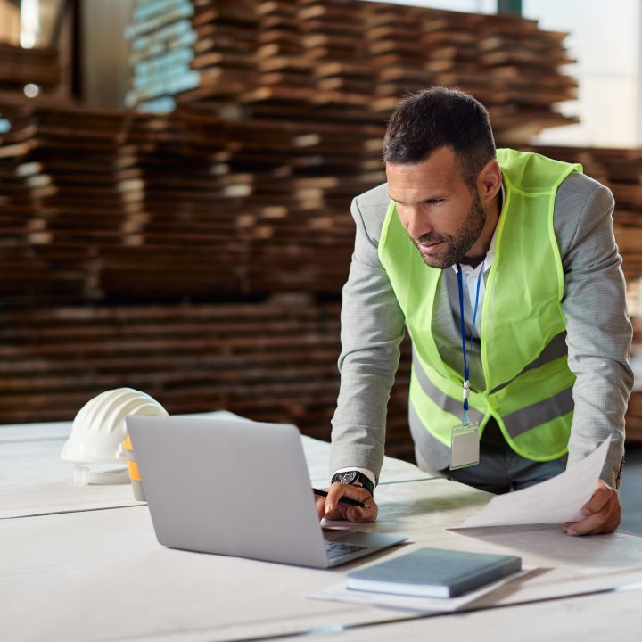 Warehouse operations manager reviewing real-time inventory data on a laptop