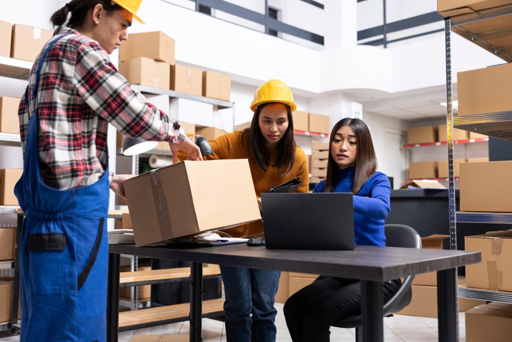 Warehouse team reviewing boxes and purchase order receiving information during inventory check